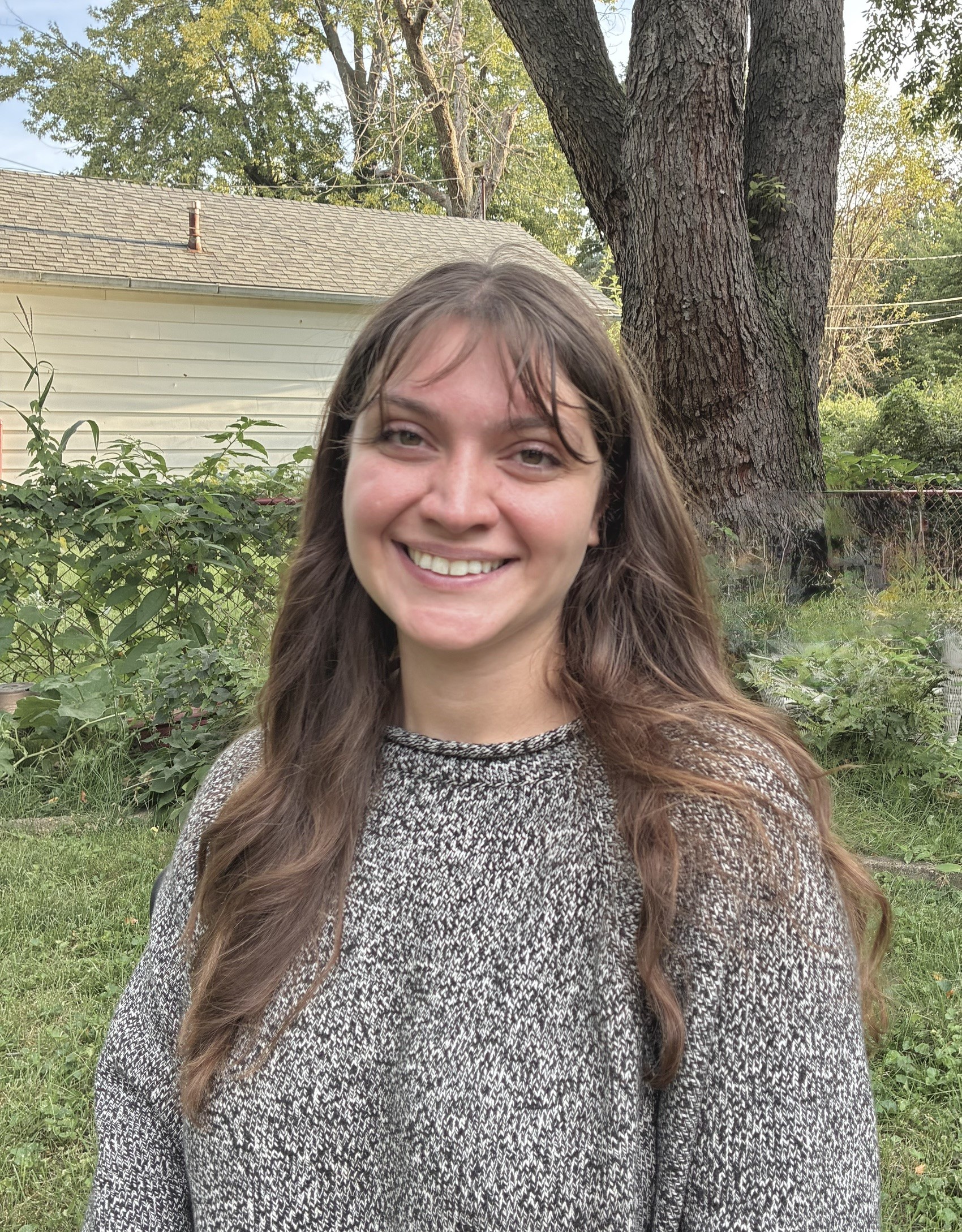 Portrait of Shauna Sloan. She has long, chest-length hair and wears a marled gray sweater.